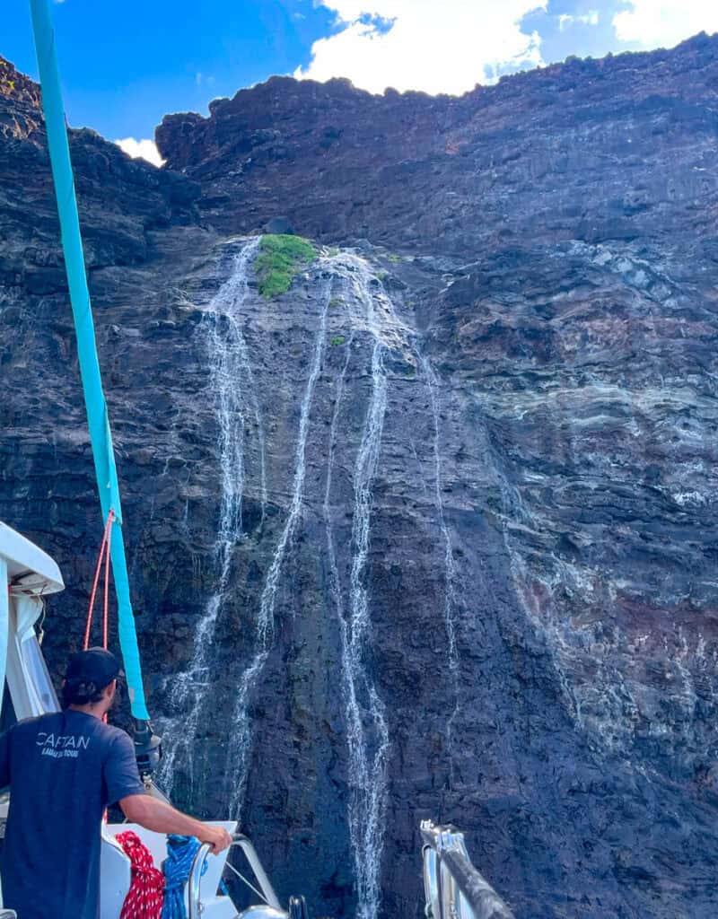 Getting close to a Na Pali Coast waterfall on a catamaran cruise in Kauai, Hawaii